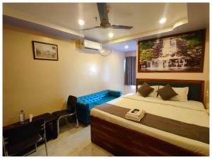 a bedroom with a bed and a chair and a couch at Hotel Plaza in Chunchura