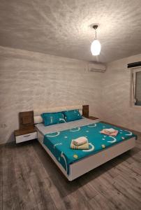 a bedroom with a large bed with a blue comforter at Villa Milla in Veles +8 photos