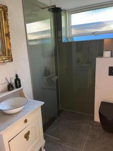 a bathroom with a glass shower and a sink at Winding B&B Silkeborg in Silkeborg