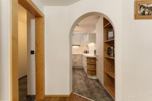 an archway leads into a kitchen with white cabinets at Auschlössl Appartements - Reiteralm in Schladming +178 photos