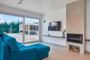 a living room with a blue couch and a fireplace at Villa the Twins in Castellammare del Golfo