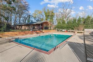 una piscina in un cortile con una casa di Classic City Getaway - Walk to Sanford Stadium ad Athens