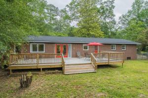 a house with a deck and a red umbrella at Restful Riverside Residence w Firepit in Athens