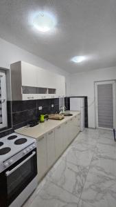 a kitchen with white cabinets and a stove top oven at Villa Milla in Veles