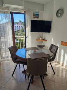 a dining room with a table and chairs and a television at Apartment Seman in Vela Luka