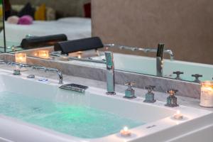 塔姆拉赫特乌兹达尔MoonLight Duplex Sea & Comfort的浴室洗手池旁放着蜡烛和镜子 更多30张照片