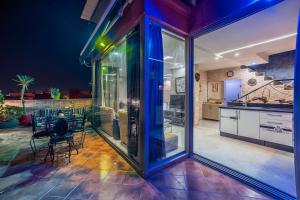 塔姆拉赫特乌兹达尔MoonLight Duplex Sea & Comfort的厨房设有玻璃门和桌椅