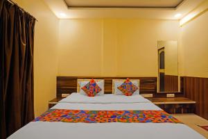 a bedroom with a large bed and a mirror at FabHotel Club Metro in Nagpur