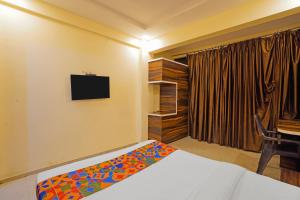 a bedroom with a bed and a television on the wall at FabHotel Club Metro in Nagpur +18 photos