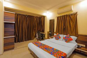 a hotel room with a large bed and a desk at FabHotel Club Metro in Nagpur