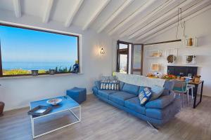 un salon avec un canapé bleu et une table dans l'établissement Villa Tarì, à Scopello