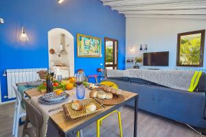 un salon bleu avec une table avec de la nourriture dessus dans l'établissement Villa Tarì, à Scopello