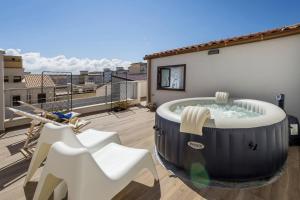 a hot tub on the balcony of a building at La Suite Di Tyche in Castellammare del Golfo