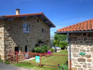 una casa in pietra con tetto rosso di Gîte Bellevue à Marols pour 6 personnes avec charmante cour fermée - FR-1-496-2 a Marols