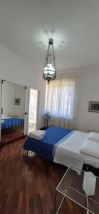 a bedroom with a large bed and a chandelier at San Vincenzo C Rooms in Genoa