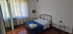 a bedroom with a bed with blue sheets and white pillows at San Vincenzo C Rooms in Genoa