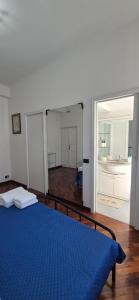 a bedroom with a blue bed and a bathroom at San Vincenzo C Rooms in Genoa