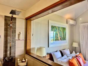 a living room with a couch and a mirror at SG17 Villa Sable Front de Mer in Palmar