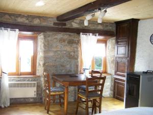 een eetkamer met een tafel, stoelen en ramen bij Gîte douillet pour 2 au cœur des Monts du Forez - FR-1-496-261 in Pralong +10 foto's