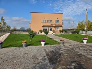 a building with potted plants in front of it at FLORA Garden Relax in Filiaşi