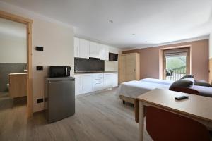 a bedroom with a bed and a kitchen with a table at Ca del Tusa in Livigno
