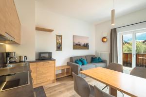 a kitchen and living room with a table and a couch at Kriendl Nr 4 in Valdaora