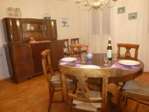 a dining room with a table with chairs and a bottle of wine at Ferienhaus Buschle in Tettnang