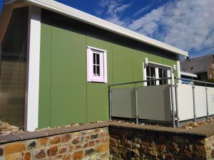 ein grünes Gebäude mit einem Fenster auf einer Ziegelmauer in der Unterkunft Ferienhaus in Bad Marienberg Westerwald mit Terrasse und Grill in Bad Marienberg