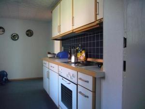 a kitchen with white cabinets and a sink and a stove at Ferienhaus Buschle in Tettnang