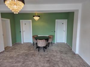 a dining room with green walls and a table and chairs at FLORA Garden Relax in Filiaşi