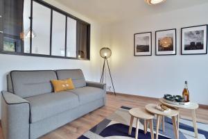 un salon avec un canapé et une table dans l'établissement La plage du Verger, à Cancale