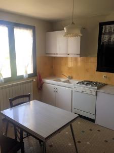 a kitchen with a table and a stove and a sink at La Maison de Campagne in Estalane