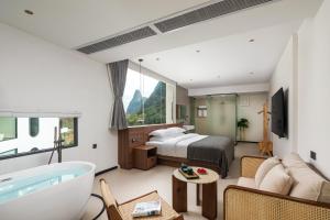 een hotelkamer met een bed en een bad bij Karst Scenic Hotel in Gaotian