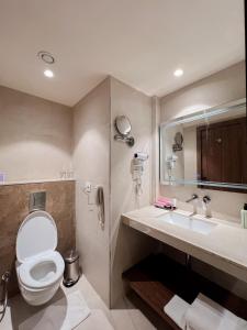 un baño con inodoro y lavabo en Tulip Inn Bhopal, en Bhopal