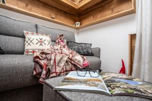 a living room with a couch and a book on a table at La Casa di Pamela in La Thuile