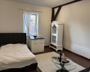 a bedroom with a bed and a table and a window at Gästehaus in Kronshagen