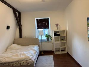 a small bedroom with a bed and a window at Gästehaus in Kronshagen