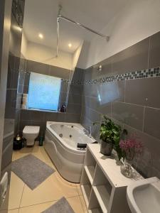 a bathroom with a tub and a toilet and a sink at Gästehaus in Kronshagen