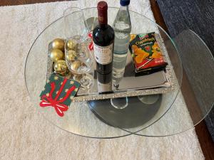 a glass table with two bottles of wine and glasses at Gästehaus in Kronshagen