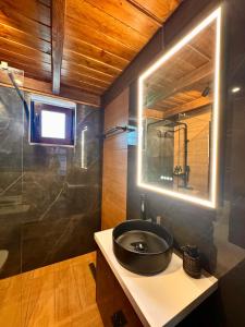 une salle de bain avec un lavabo noir et un miroir dans l'établissement Angie Kipos by Thanasis Papaioannou, à Evangelístria