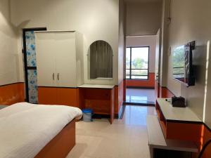 a bedroom with a bed and a sink and a mirror at Hotel Jain's Inn in Chhuīkhadān