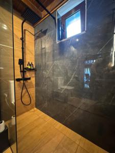 une douche avec une porte vitrée dans une salle de bain dans l'établissement Angie Kipos by Thanasis Papaioannou, à Evangelístria 5 autres photos