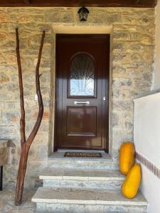 une porte d'entrée d'une maison avec des citrouilles sur les marches dans l'établissement Angie Kipos by Thanasis Papaioannou, à Evangelístria