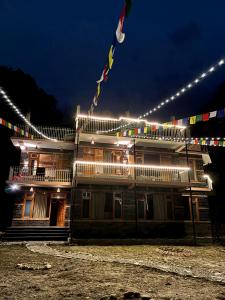a building with a flag on top of it at night at the pahadi ghar in Gushaini