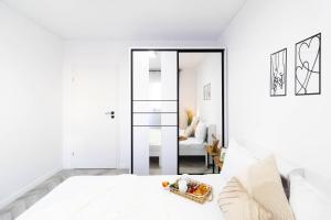 Un dormitorio blanco con una cama blanca y un espejo. en Amaria Sunrise, en Popeşti-Leordeni 19 fotos más
