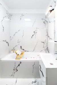 Un baño blanco con bañera y lavabo. en Amaria Sunrise, en Popeşti-Leordeni