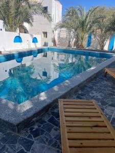 a swimming pool with a chair in the water at Bait Gamal Siwa بيت جمال سيوة in Siwa