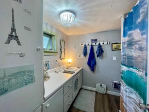 un bagno con lavandino e una torre appesa al muro di Mattawamkeag River Cottage a Island Falls