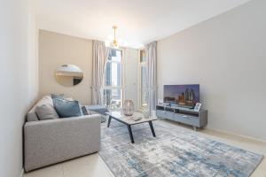 a living room with a couch and a tv at Urban Chic - Mangrove Place in Abu Dhabi