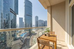 a balcony with a wooden table and a view of a city at Urban Chic - Mangrove Place in Abu Dhabi
